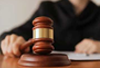 Stock image of hand pounding the judge's gavel with black robe in background.