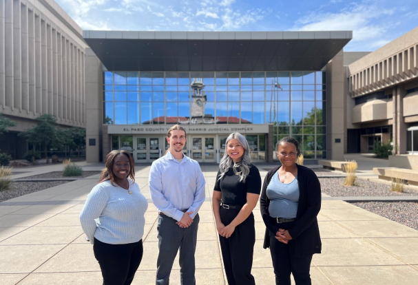 Four professionals standing outside in front of the El Paso Courthouse.
